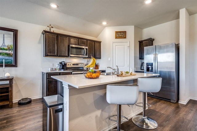 kitchen featuring dark brown cabinetry, stainless steel appliances, sink, a center island with sink, and lofted ceiling