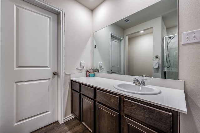 bathroom with a shower, vanity, and wood-type flooring