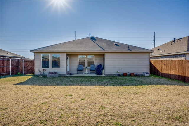 rear view of house featuring a lawn and a patio area