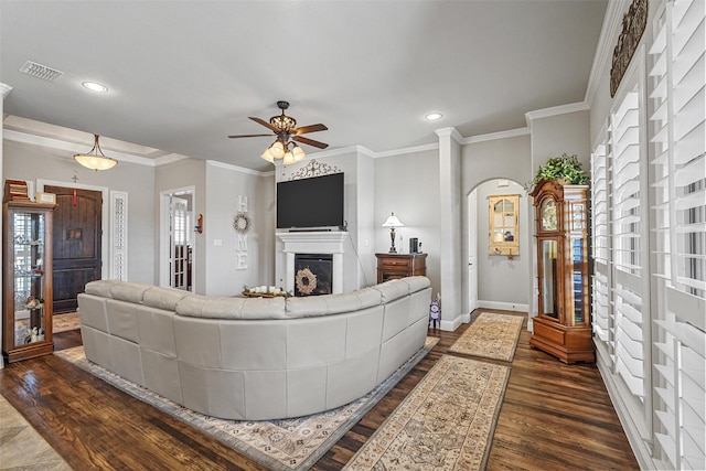 living room with ornamental molding, dark hardwood / wood-style floors, and ceiling fan