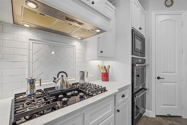 kitchen with built in microwave, light stone countertops, custom range hood, and white cabinets