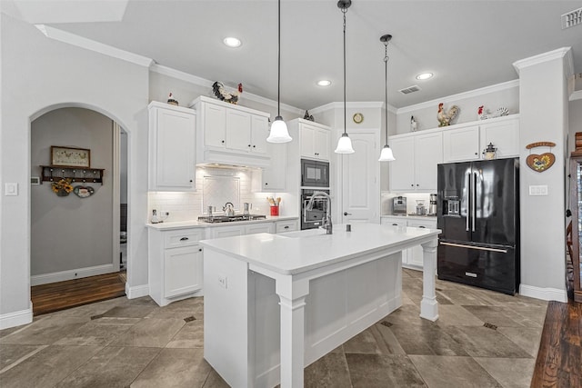 kitchen featuring backsplash, black appliances, a center island with sink, white cabinetry, and hanging light fixtures