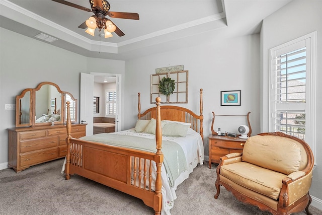 bedroom featuring multiple windows, a raised ceiling, and ceiling fan