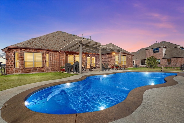 pool at dusk featuring a pergola, a yard, and a patio area