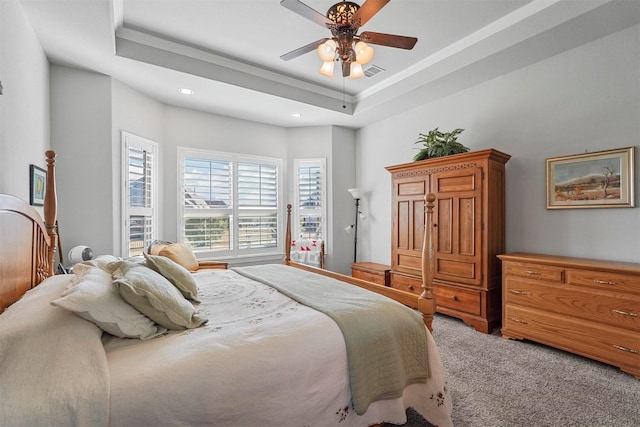 bedroom with a raised ceiling, ornamental molding, carpet flooring, and ceiling fan