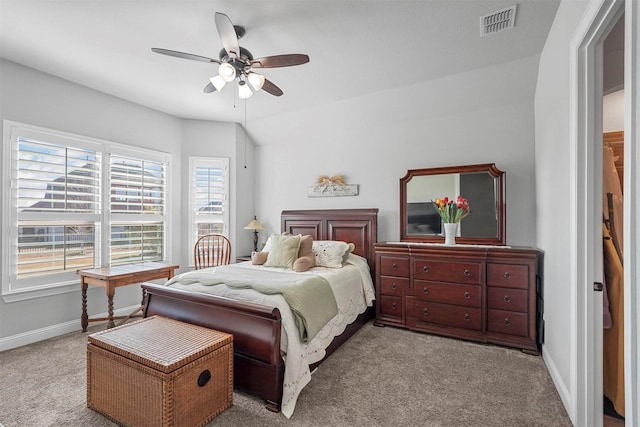 carpeted bedroom featuring multiple windows, ceiling fan, and vaulted ceiling