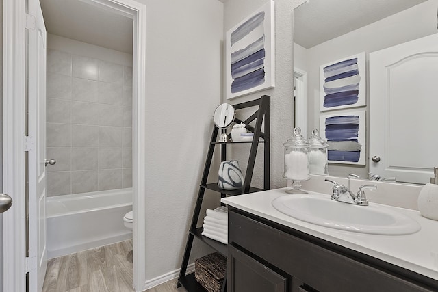 full bathroom with vanity, toilet, wood-type flooring, and tiled shower / bath combo