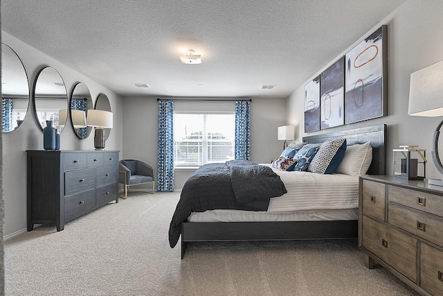 bedroom with a textured ceiling and light carpet