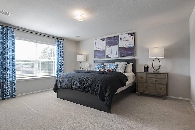 bedroom featuring light colored carpet and a textured ceiling