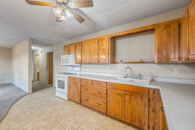 kitchen featuring sink, white appliances, a textured ceiling, and ceiling fan