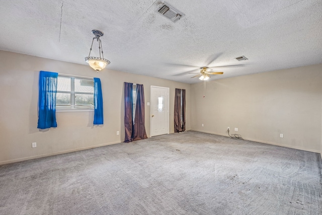 spare room with ceiling fan, a textured ceiling, and carpet