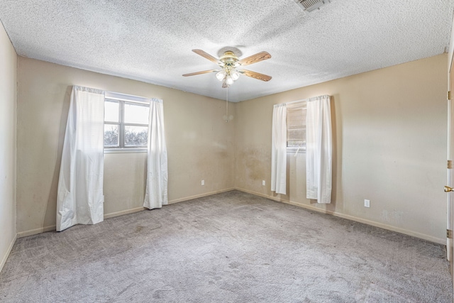 carpeted spare room with a textured ceiling and ceiling fan