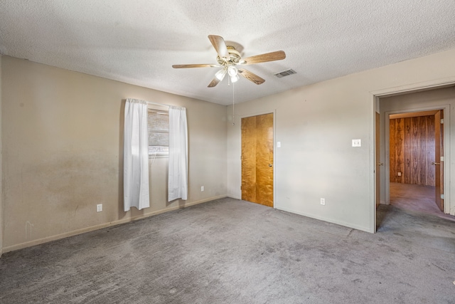 unfurnished bedroom with ceiling fan, carpet floors, and a textured ceiling