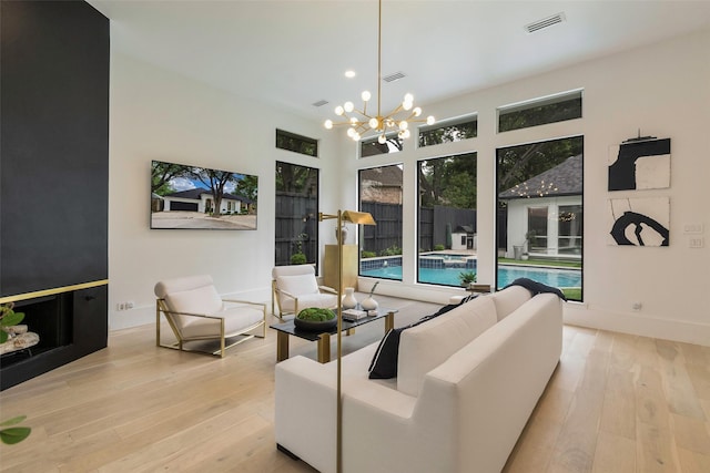 living room with an inviting chandelier and light hardwood / wood-style flooring