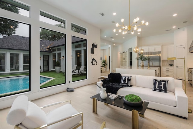 living room featuring a notable chandelier, a healthy amount of sunlight, and sink