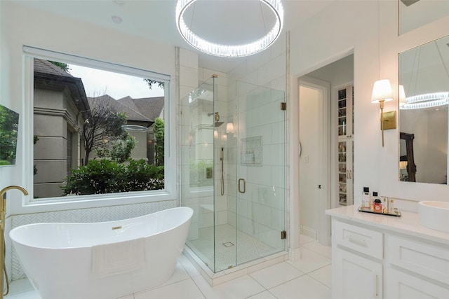 bathroom with tile patterned floors, vanity, and shower with separate bathtub