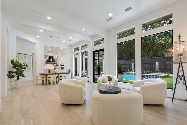 interior space with a chandelier, visible vents, recessed lighting, light wood-type flooring, and beam ceiling