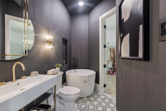 bathroom with sink, a bathtub, and toilet