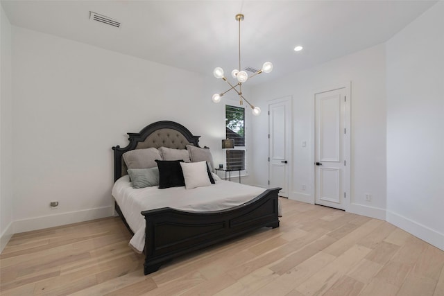 bedroom with light hardwood / wood-style flooring and a notable chandelier