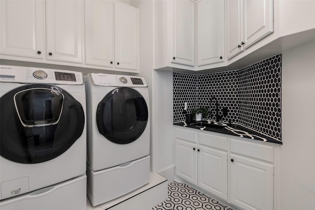 clothes washing area featuring light tile patterned flooring, cabinets, and washing machine and clothes dryer