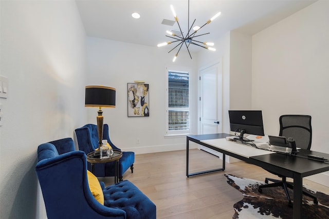 home office featuring light wood-type flooring and an inviting chandelier