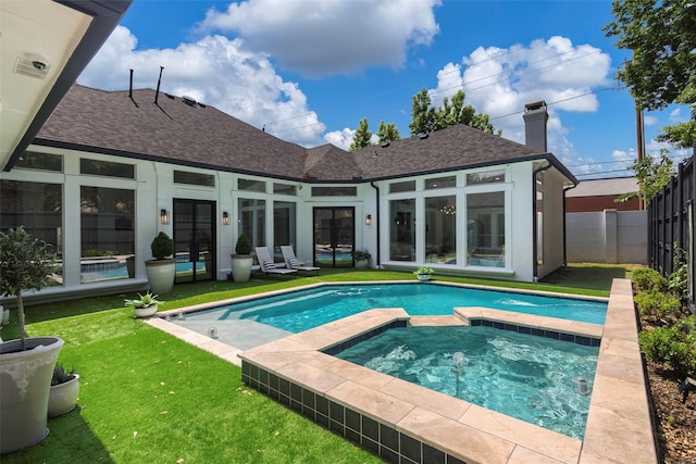 view of swimming pool with a lawn and an in ground hot tub