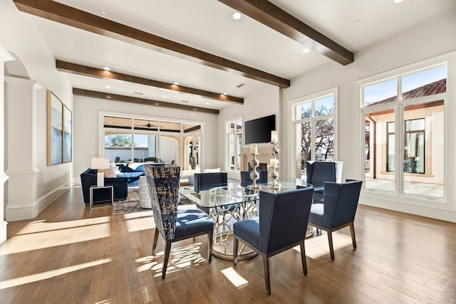 dining area with ornate columns, wood-type flooring, ceiling fan, and beam ceiling