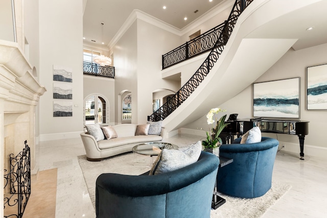 living room with ornamental molding, a towering ceiling, and a high end fireplace