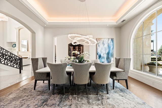 dining room featuring a raised ceiling and a notable chandelier