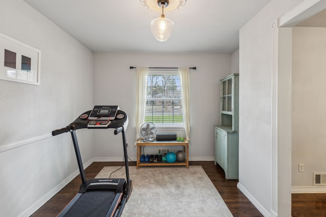 workout area featuring dark wood-type flooring