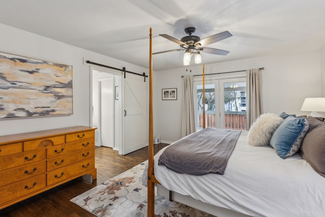 bedroom featuring access to outside, a barn door, ceiling fan, and dark wood-type flooring