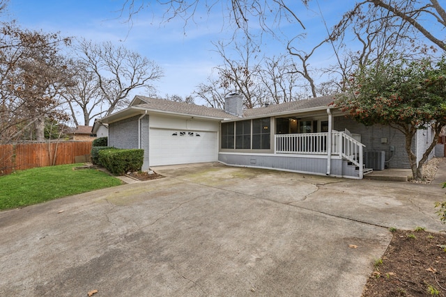 view of front of property featuring central AC, a porch, a front yard, and a garage