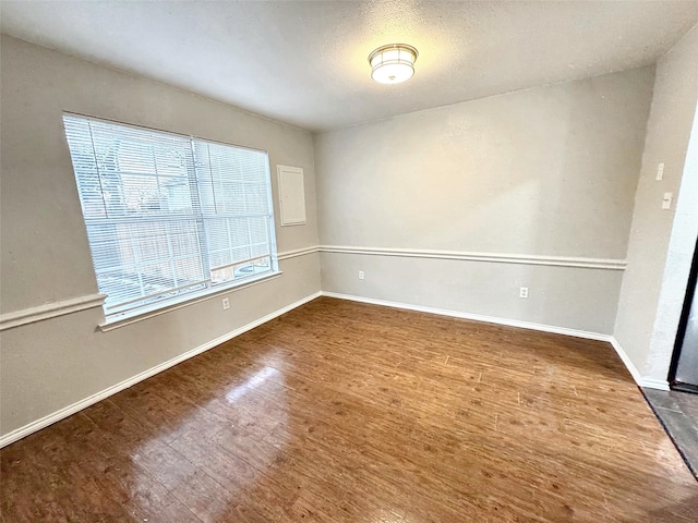 unfurnished room with hardwood / wood-style flooring