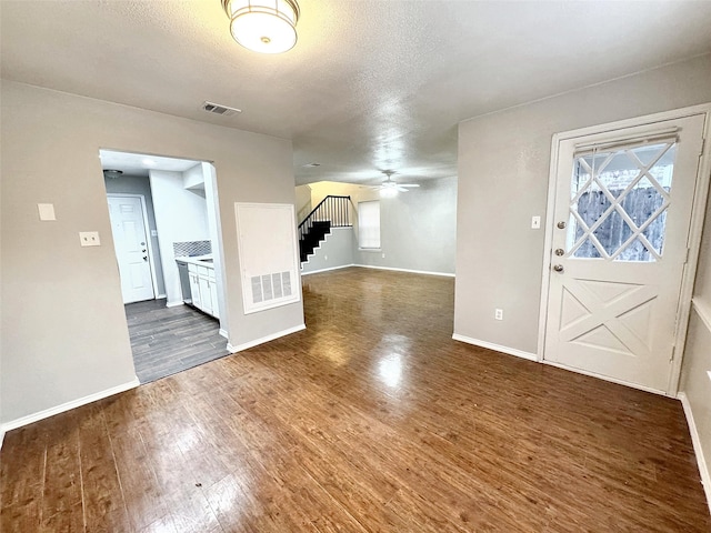 foyer featuring dark hardwood / wood-style flooring, ceiling fan, and a textured ceiling