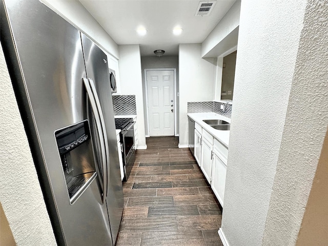 kitchen with tasteful backsplash, sink, stainless steel appliances, and white cabinets