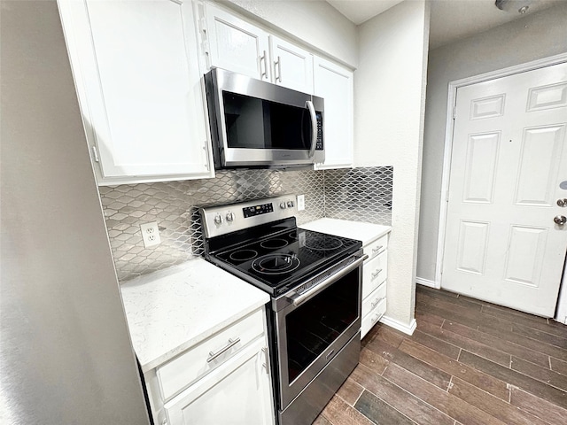 kitchen with stainless steel appliances, white cabinetry, and tasteful backsplash