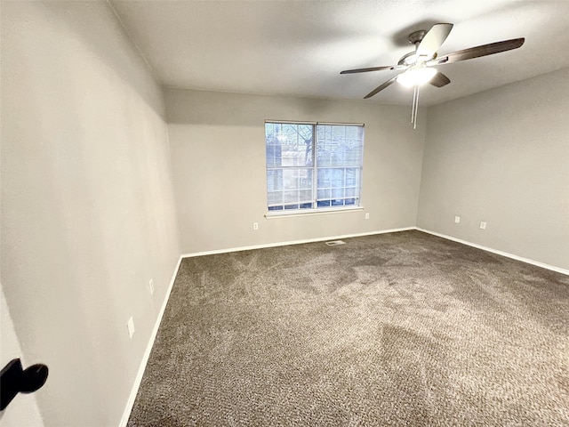 unfurnished room with ceiling fan and carpet