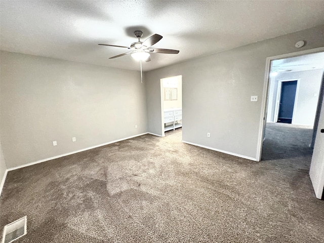 carpeted empty room featuring ceiling fan and a textured ceiling