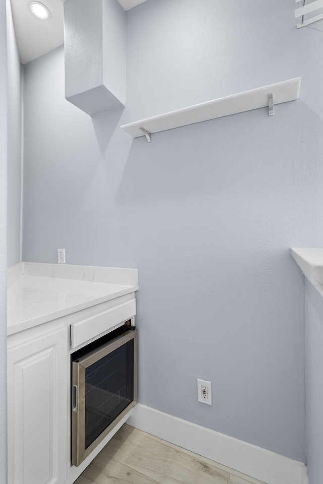 room details with beverage cooler, wood finished floors, and baseboards