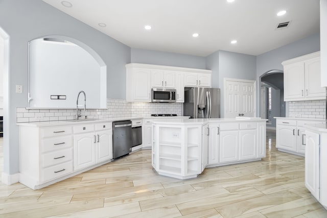 kitchen with white cabinets, a center island, sink, and appliances with stainless steel finishes