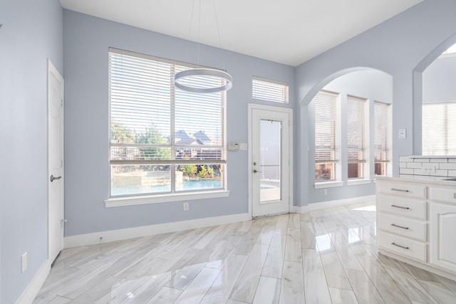 doorway with a healthy amount of sunlight and baseboards