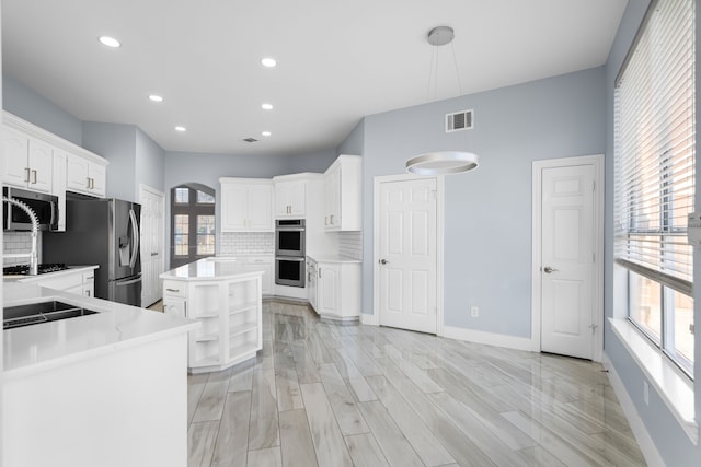 kitchen featuring stainless steel appliances, a wealth of natural light, visible vents, and white cabinetry