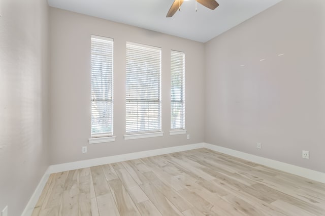 empty room with a ceiling fan, baseboards, and wood finished floors