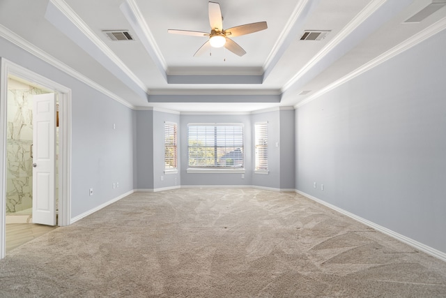 carpeted empty room featuring ceiling fan, crown molding, visible vents, and a tray ceiling