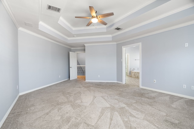 unfurnished bedroom with baseboards, carpet, visible vents, and a tray ceiling