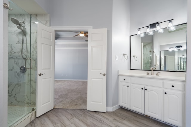 bathroom featuring ceiling fan, a shower with door, and vanity