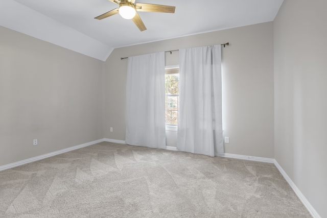 carpeted spare room with ceiling fan, lofted ceiling, and baseboards