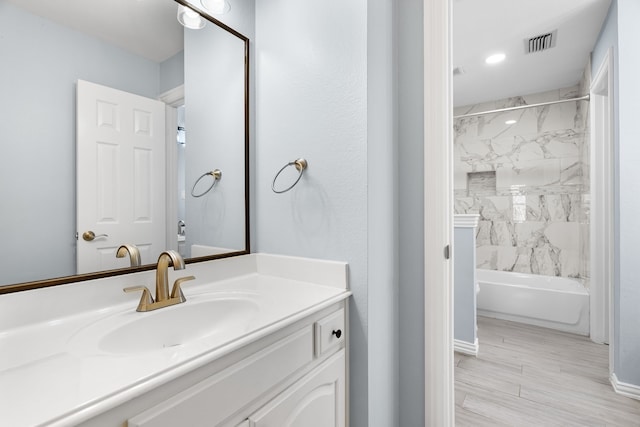 bathroom featuring vanity and tiled shower / bath