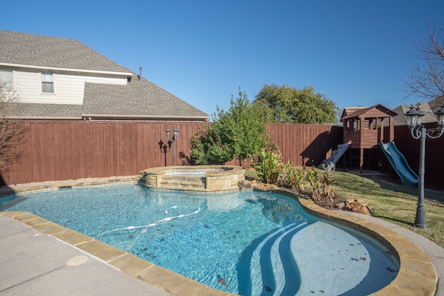 view of pool featuring a fenced backyard, a pool with connected hot tub, and a playground