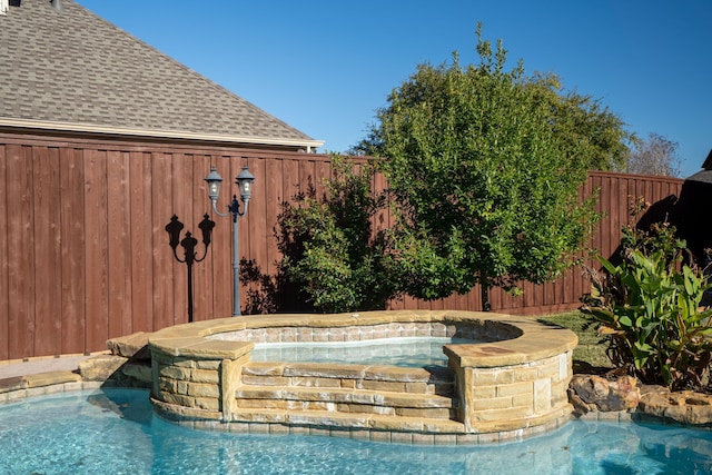 view of pool with a pool with connected hot tub and a fenced backyard